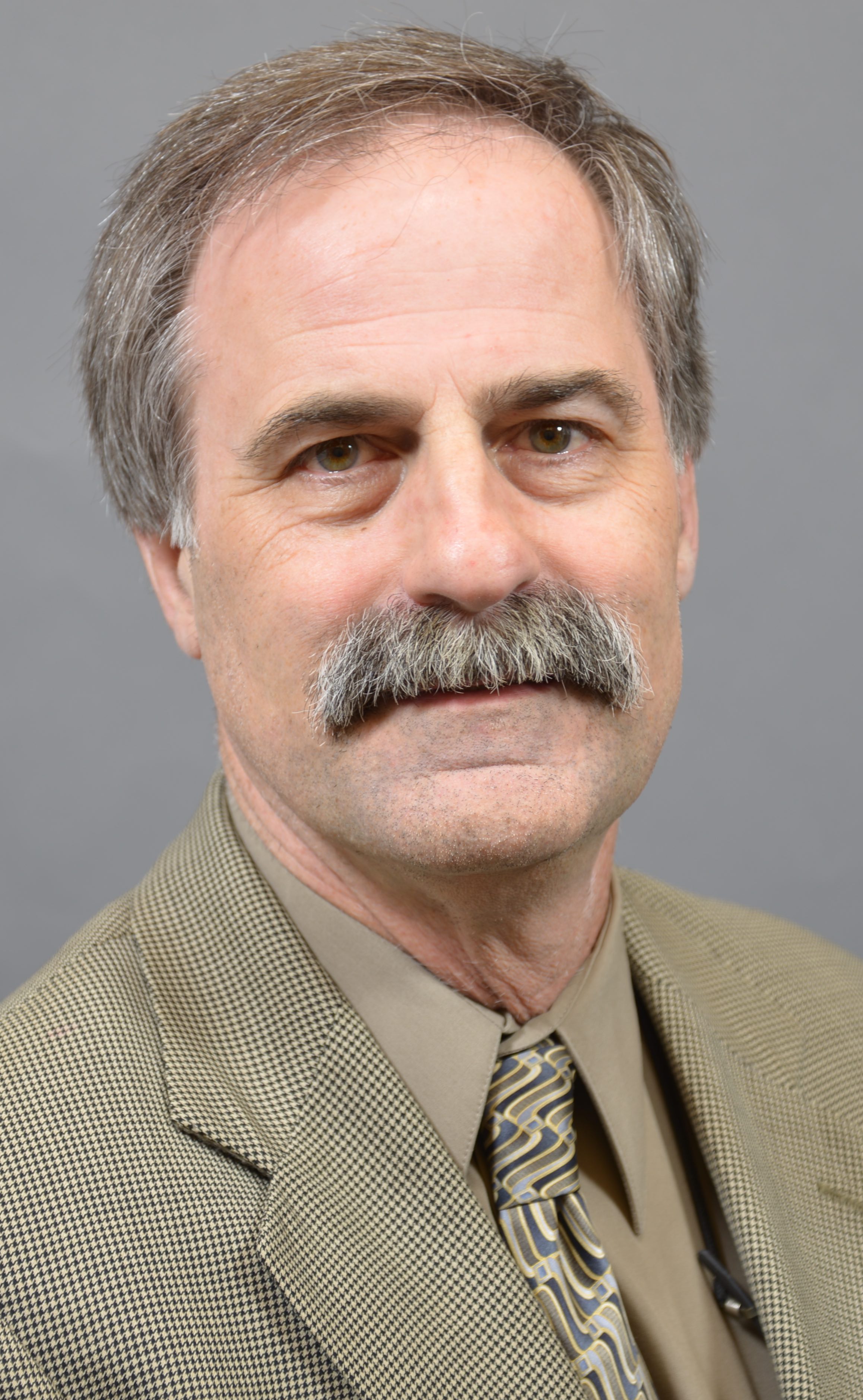 a man with a moustache smiling